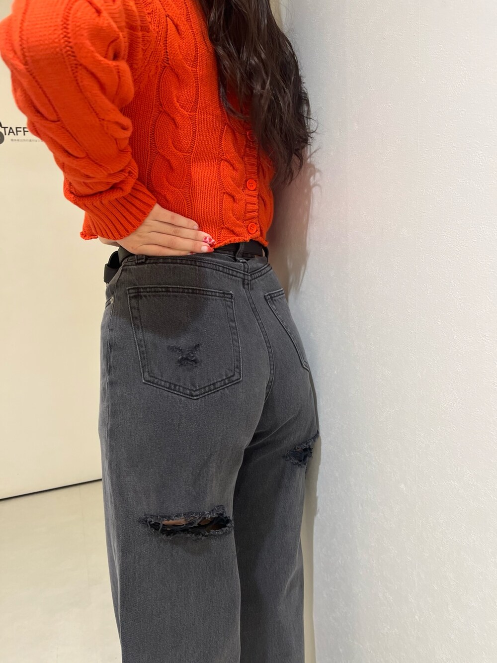 オレンジ系のカーディガン/ボレロ、ブラック系のデニムパンツ、ブラック系のショルダーバッグを着用したレディースの冬コーディネートの5枚目の写真