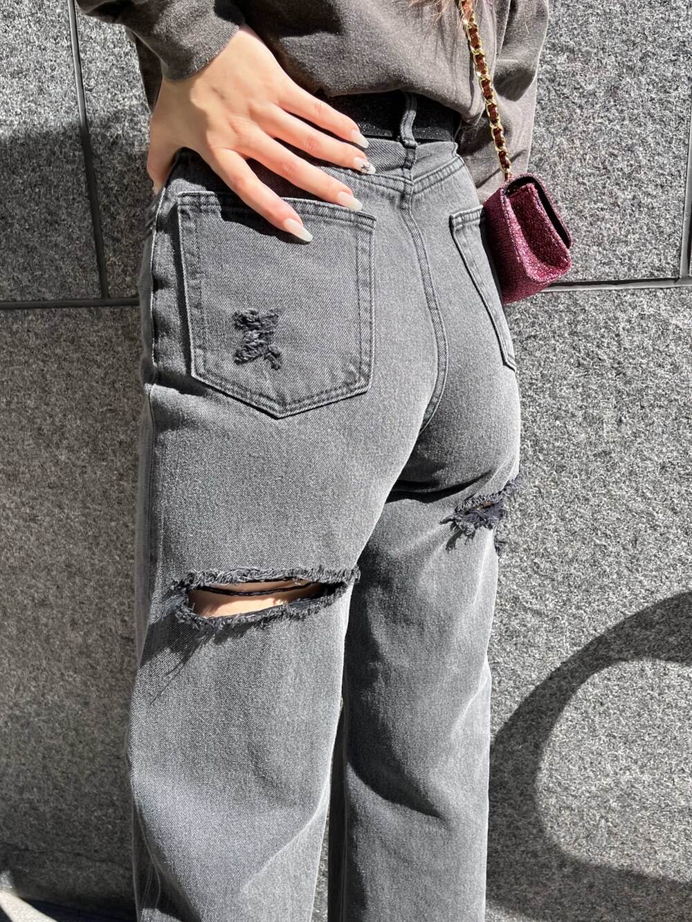 グレー系のTシャツ/カットソー、ブラック系のデニムパンツ、ピンク系のショルダーバッグを着用したレディースの冬コーディネートの6枚目の写真