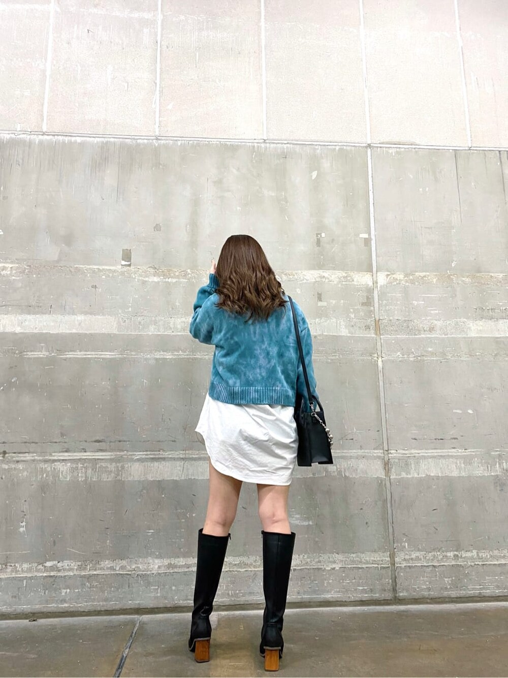 ブラック系のブーツ、ブルー系のニット/セーター、ホワイト系のシャツ/ブラウスを着用したレディースの秋コーディネートの2枚目の写真