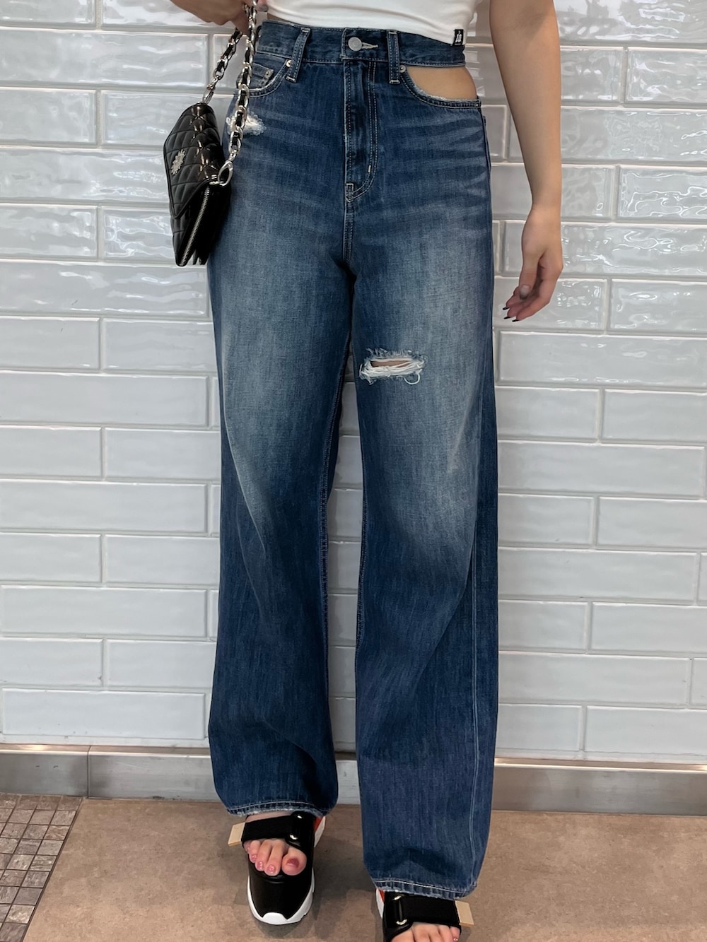 ホワイト系のTシャツ/カットソー、ブラック系のサンダル、ブラック系のショルダーバッグを着用したレディースの夏コーディネートの5枚目の写真