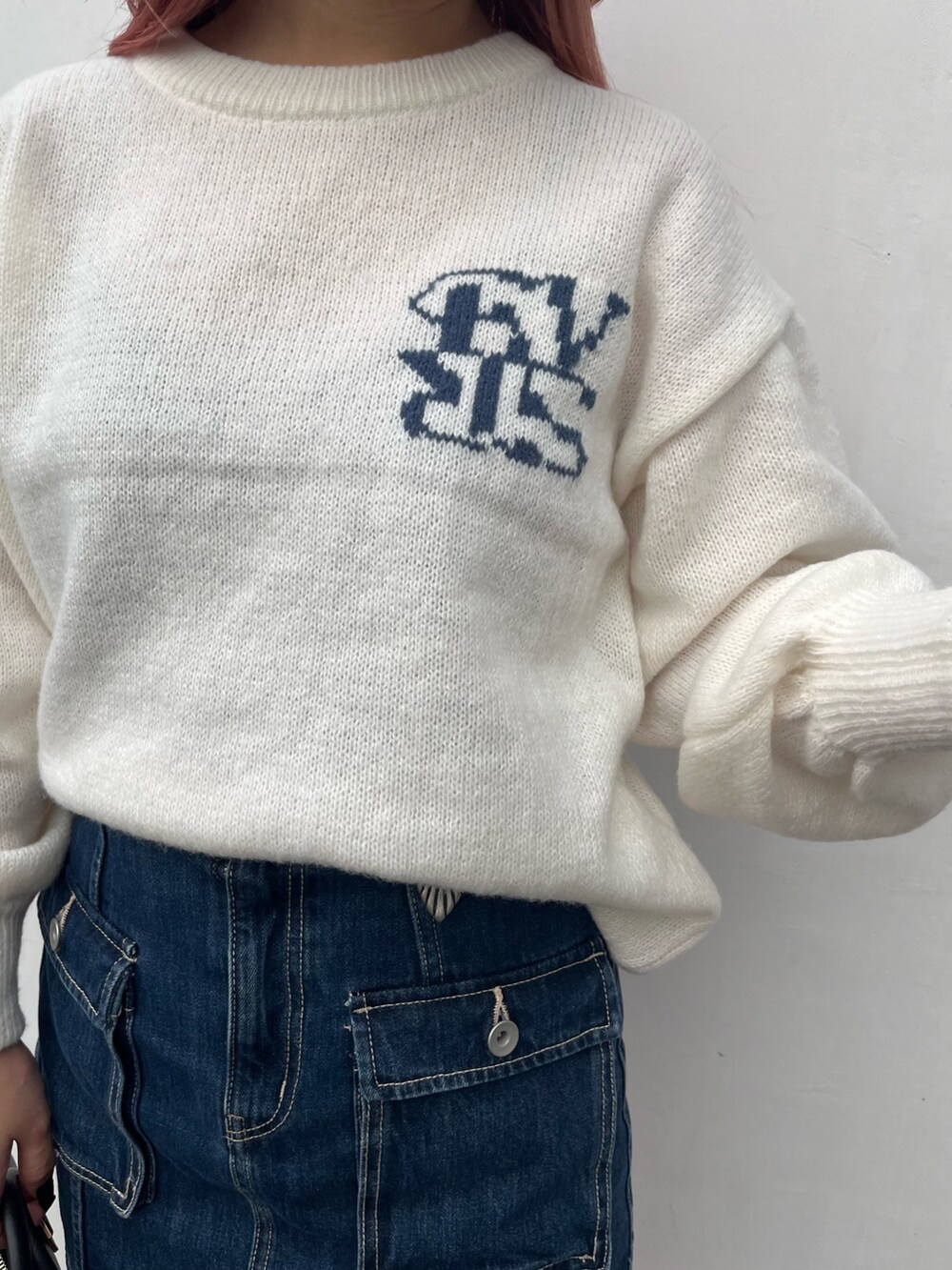 ホワイト系のニット/セーター、ブルー系のデニムスカート、ブラック系のボストンバッグを着用したレディースの冬コーディネートの4枚目の写真