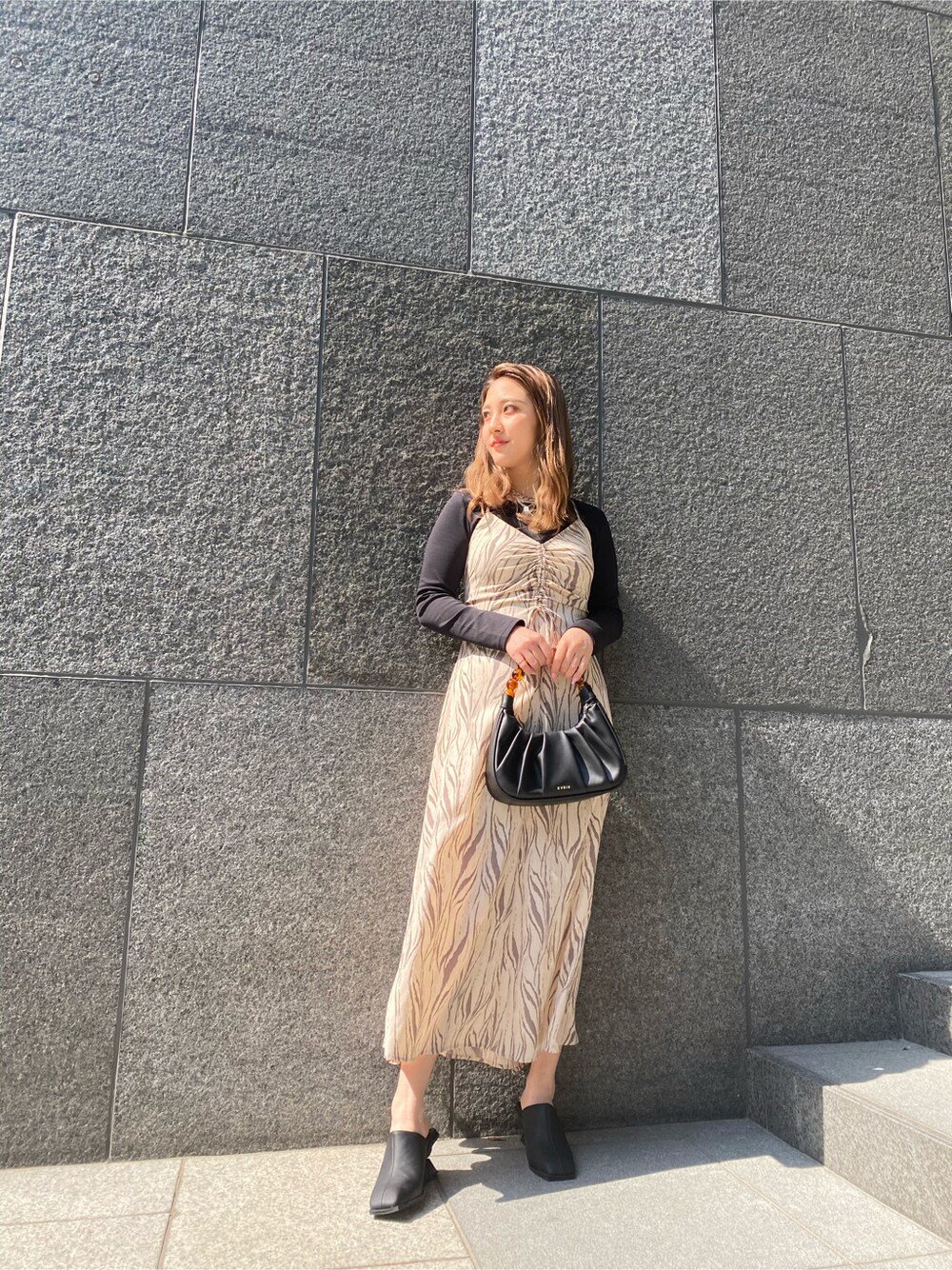 その他のワンピース、ブラック系のハンドバッグ、ブラック系のサンダルを着用したレディースの春コーディネートの2枚目の写真