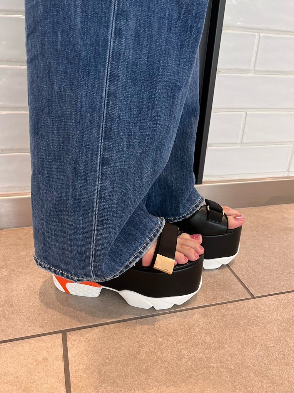 ホワイト系のTシャツ/カットソー、ブラック系のサンダル、ブラック系のショルダーバッグを着用したレディースの夏コーディネートの8枚目の写真