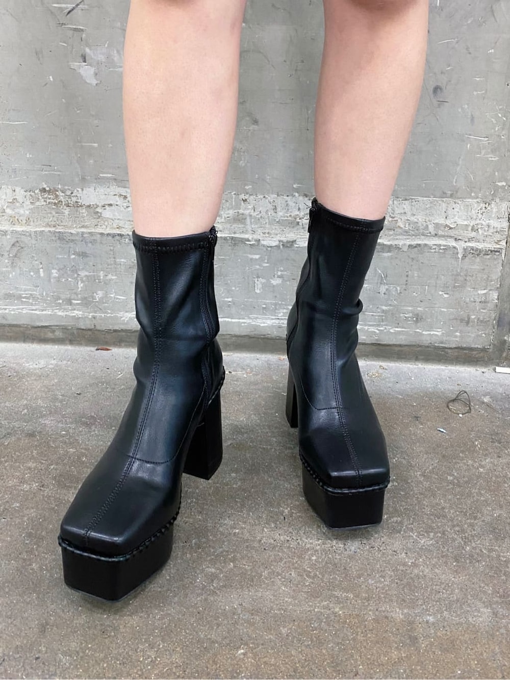 ブラック系のワンピース、ブラック系のショルダーバッグ、ブラック系のブーツを着用したレディースの秋コーディネートの7枚目の写真