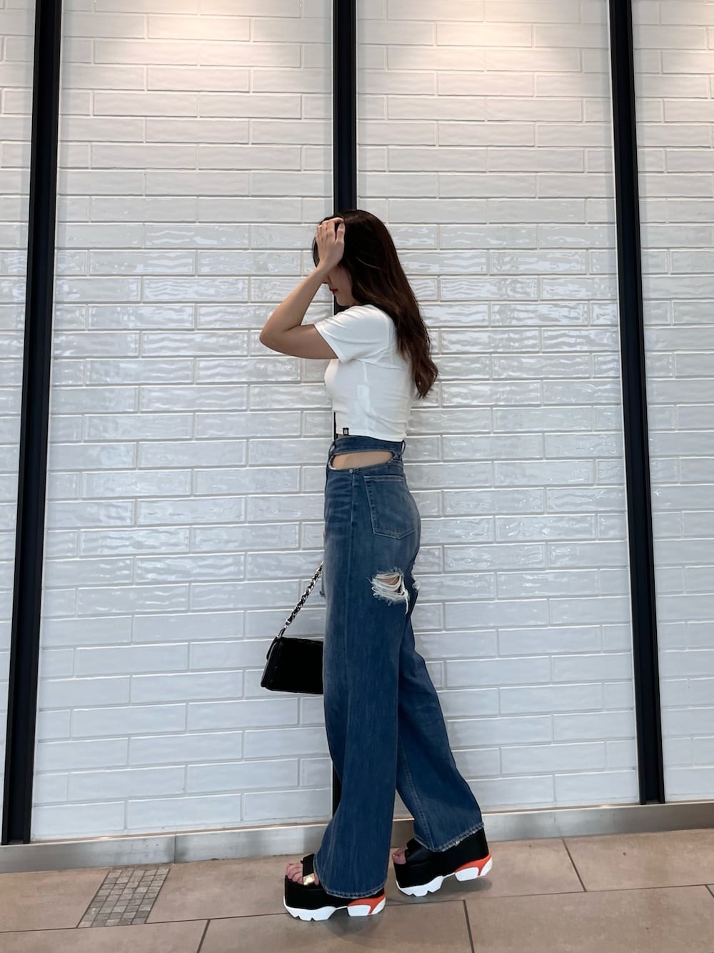 ホワイト系のTシャツ/カットソー、ブラック系のサンダル、ブラック系のショルダーバッグを着用したレディースの夏コーディネートの3枚目の写真