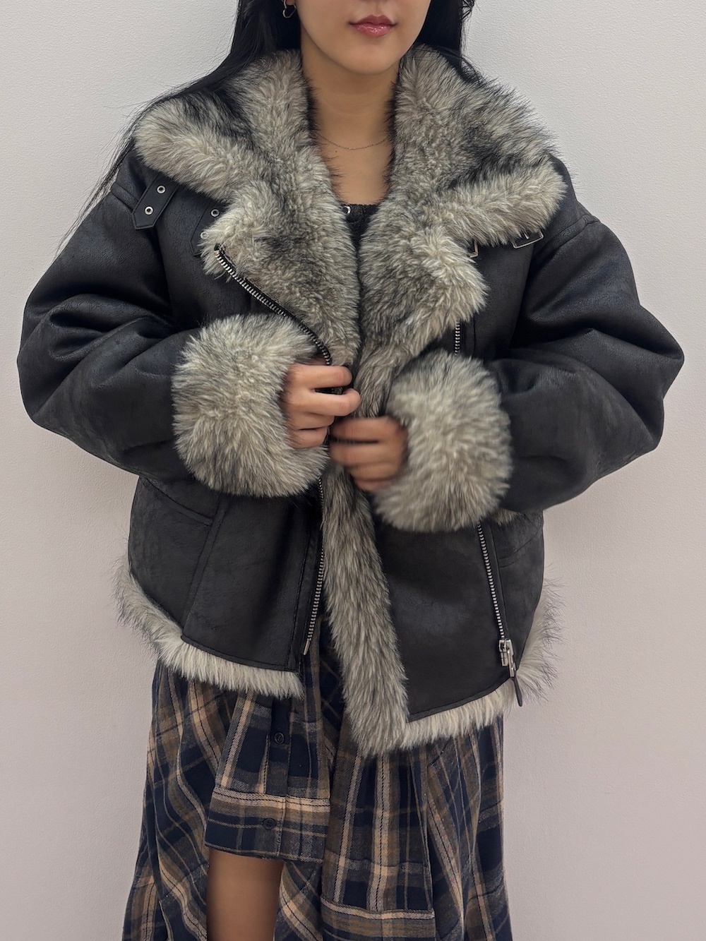 ブラック系のブルゾン、ブラック系のニット/セーター、ブルー系のスカートを着用したレディースの秋コーディネートの4枚目の写真