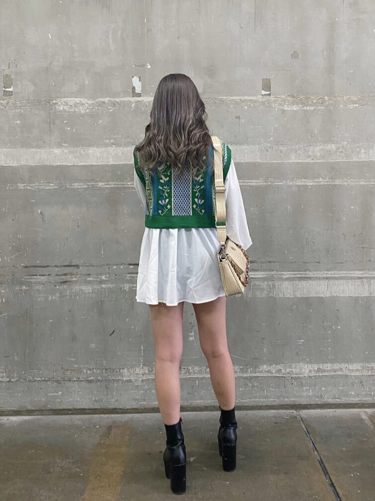 ホワイト系のショルダーバッグ、グリーン系のシャツ/ブラウス、ブラック系のブーツを着用したレディースの冬コーディネートの2枚目の写真