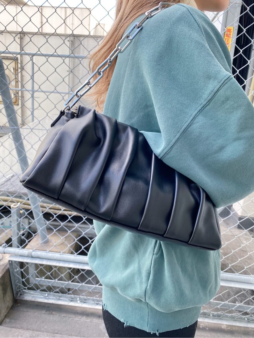 ブラック系のブーツ、ブラック系のショルダーバッグ、グリーン系のスウェットを着用したレディースの秋コーディネートの7枚目の写真