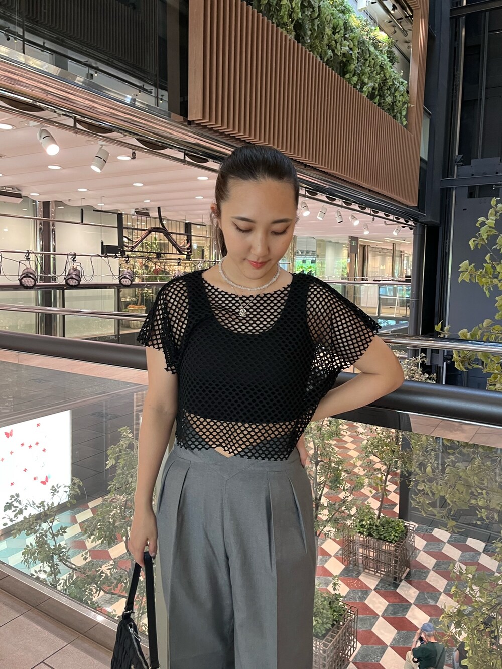 ブラック系のTシャツ/カットソー、グレー系のその他パンツ、ブラック系のハンドバッグを着用したレディースの夏コーディネートの3枚目の写真