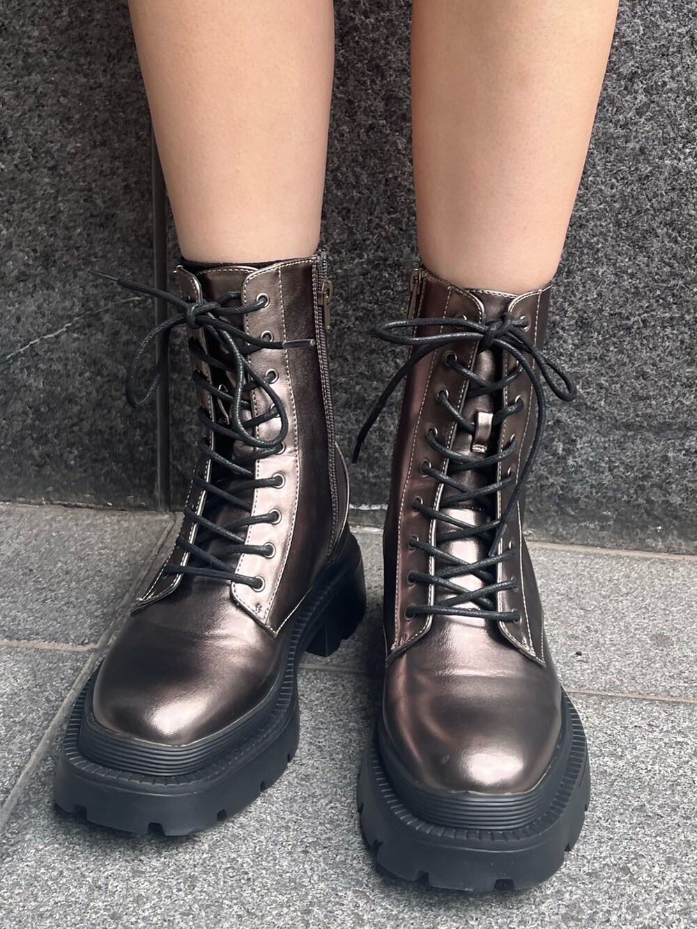 ブラック系のパーカー、ブラック系のハンドバッグ、シルバー系のブーツを着用したレディースの冬コーディネートの5枚目の写真