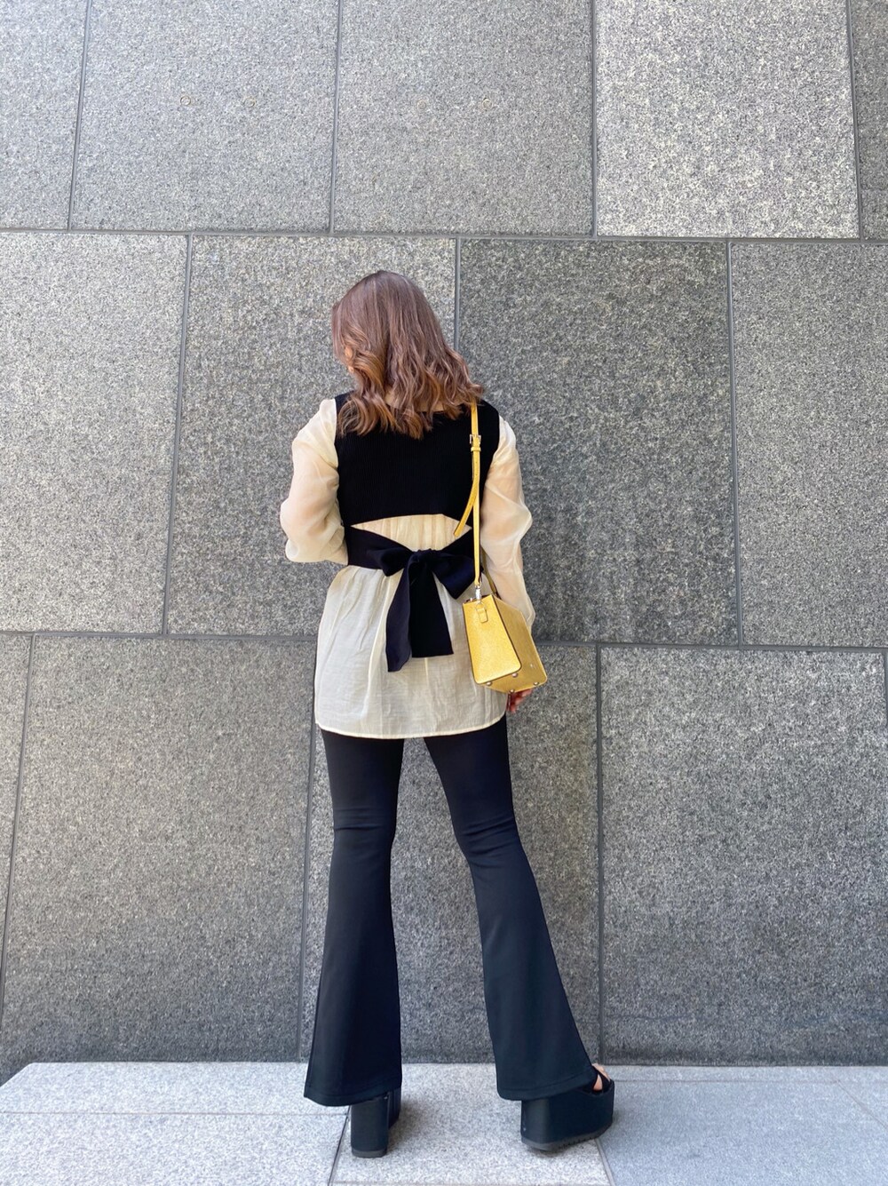 ブラック系のタンクトップ、ホワイト系のシャツ/ブラウス、ブラック系のサンダルを着用したレディースの春コーディネートの2枚目の写真