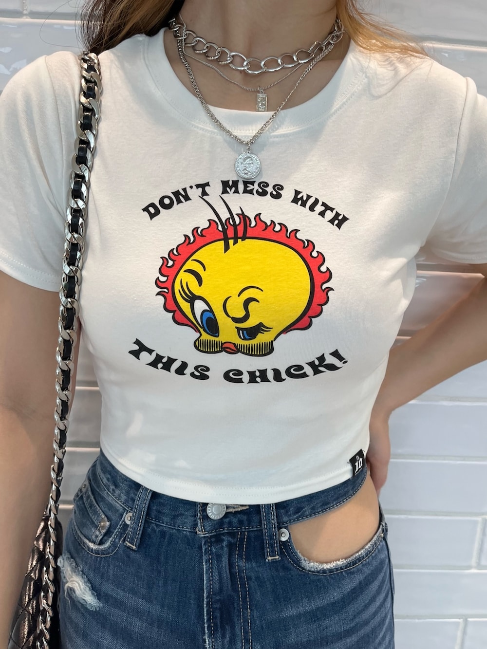 ホワイト系のTシャツ/カットソー、ブラック系のサンダル、ブラック系のショルダーバッグを着用したレディースの夏コーディネートの4枚目の写真