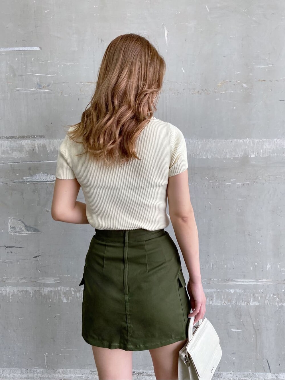 ホワイト系のサンダル、ベージュ系のスカート、ホワイト系のニット/セーターを着用したレディースの夏コーディネートの5枚目の写真