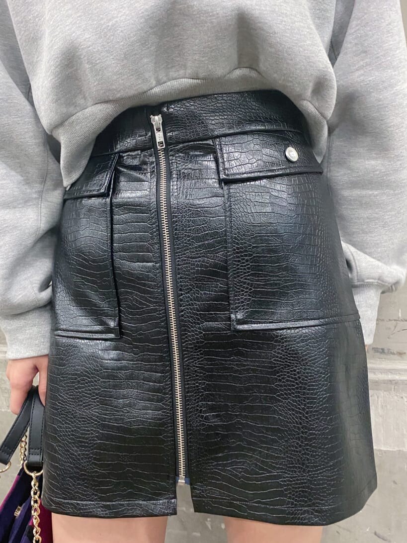 ブラック系のブーツ、グレー系のスウェット、ブラック系のスカートを着用したレディースの冬コーディネートの5枚目の写真