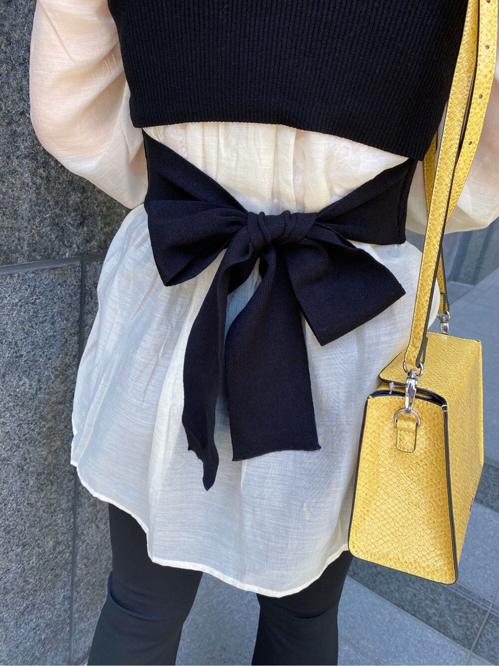 ブラック系のタンクトップ、ホワイト系のシャツ/ブラウス、ブラック系のサンダルを着用したレディースの春コーディネートの3枚目の写真