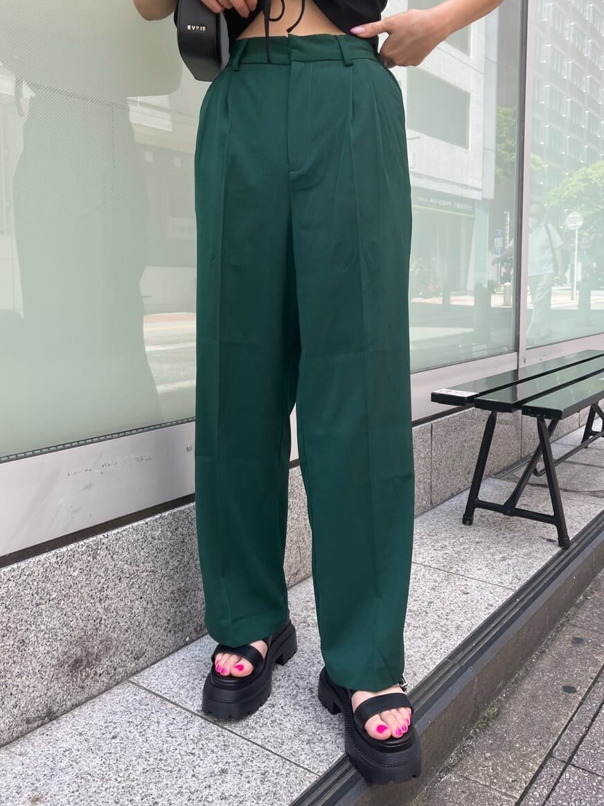 グリーン系のスラックス、ブラック系のショルダーバッグ、ブラック系のTシャツ/カットソーを着用したレディースの夏コーディネートの5枚目の写真