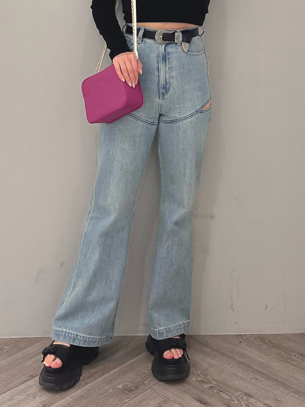 ブルー系のデニムパンツ、ブラック系のニット/セーター、パープル系のショルダーバッグを着用したレディースの春コーディネートの5枚目の写真