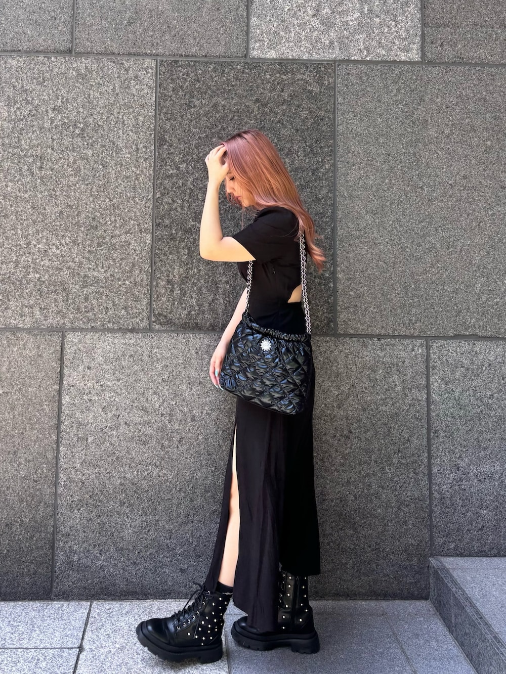 ブラック系のワンピース、ブラック系のショルダーバッグ、ブラック系のブーツを着用したレディースの春コーディネートの3枚目の写真