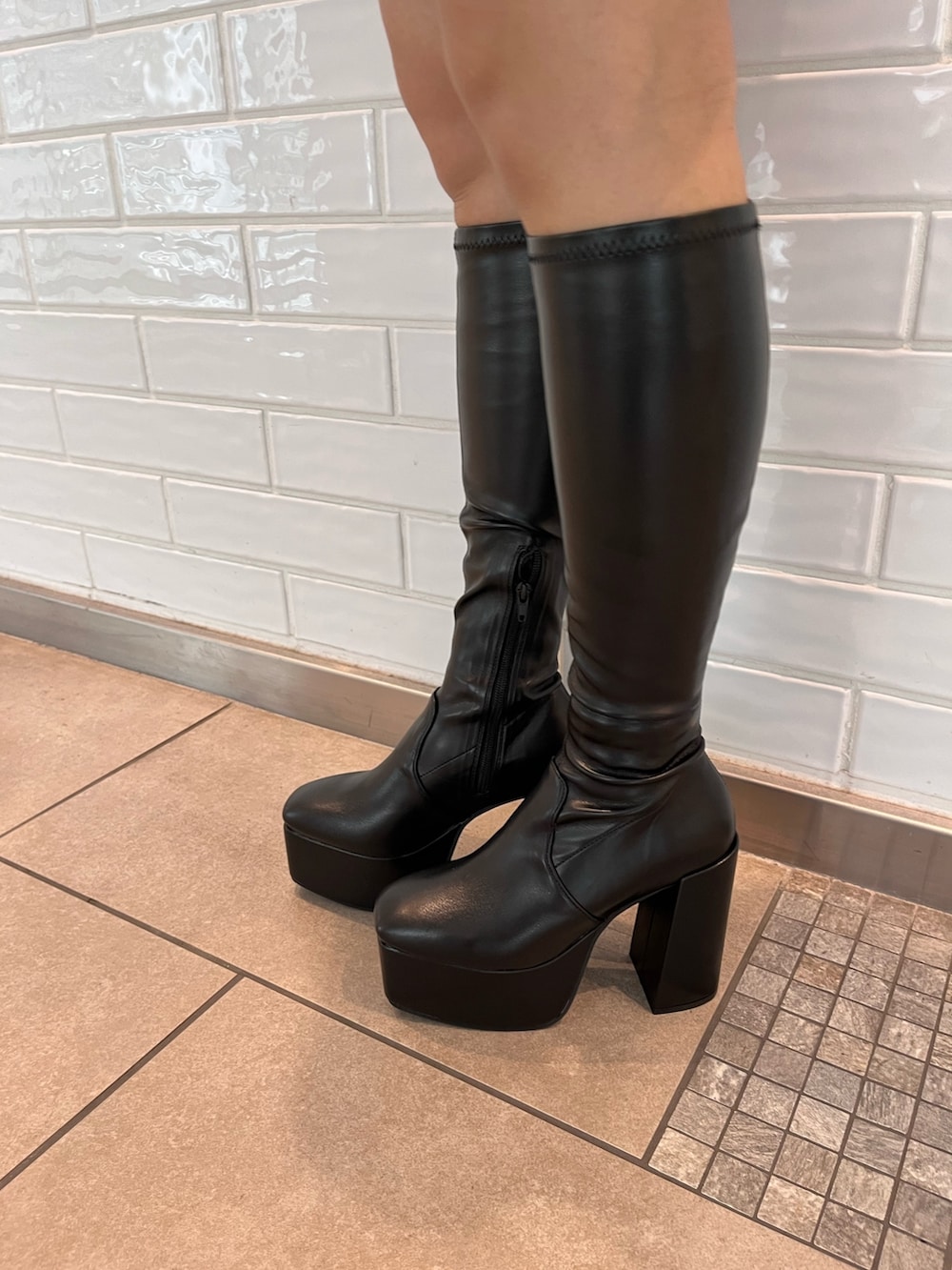 グリーン系のカーディガン/ボレロ、ホワイト系のキャミソール、ブラック系のデニムスカートを着用したレディースの秋コーディネートの5枚目の写真