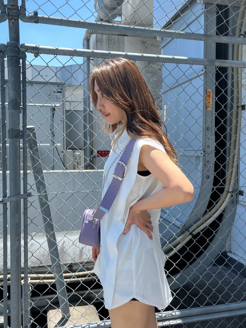 ブラック系のデニムパンツ、ホワイト系のシャツ/ブラウス、パープル系のショルダーバッグを着用したレディースの夏コーディネートの5枚目の写真