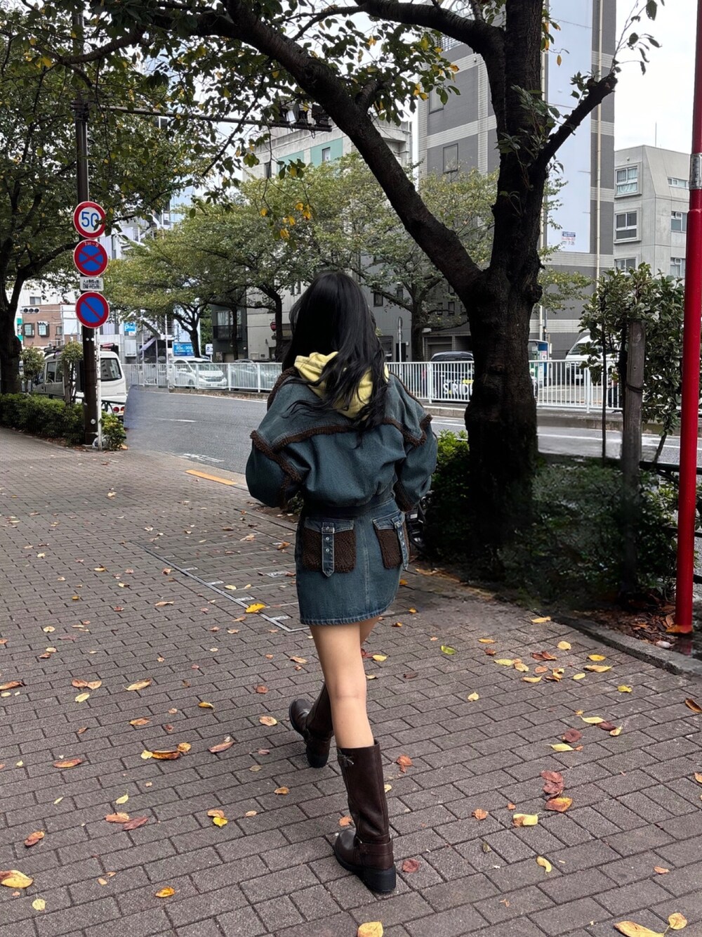 ブルー系のブルゾン、イエロー系のスウェット、ブルー系のデニムスカートを着用したレディースの秋コーディネートの3枚目の写真