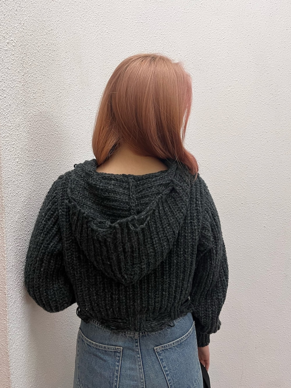 ブルー系のデニムパンツ、ブラック系のハンドバッグ、ブラック系のブーツを着用したレディースの冬コーディネートの5枚目の写真