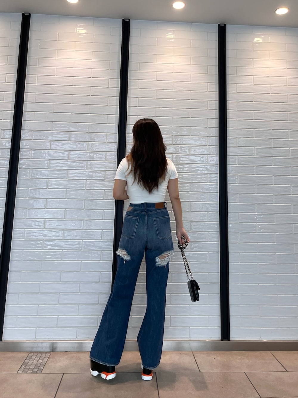 ホワイト系のTシャツ/カットソー、ブラック系のサンダル、ブラック系のショルダーバッグを着用したレディースの夏コーディネートの2枚目の写真