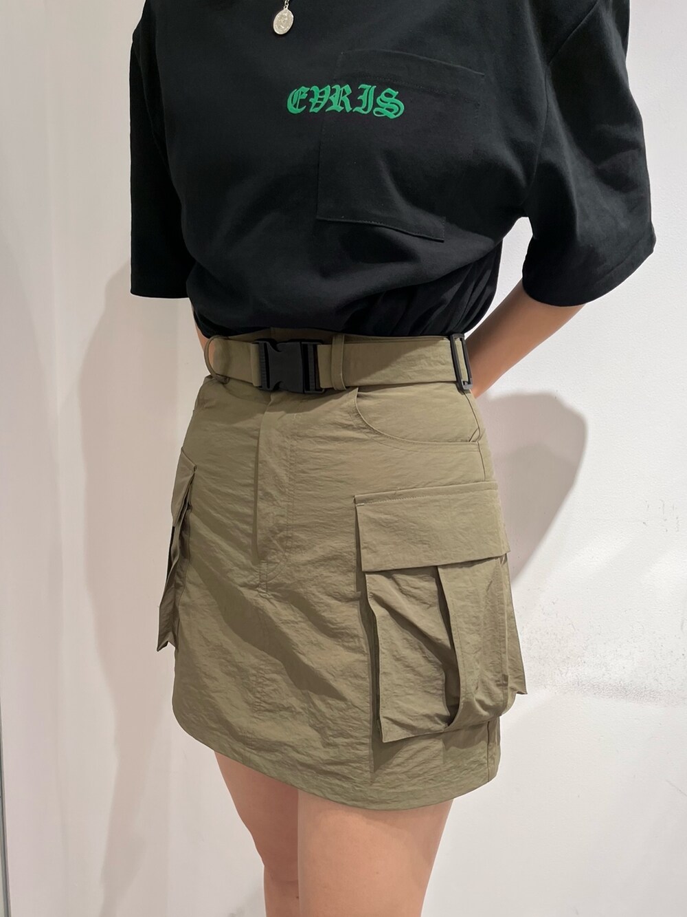 ブラック系のTシャツ/カットソー、グリーン系のスカート、ブラック系のブーツを着用したレディースの夏コーディネートの5枚目の写真