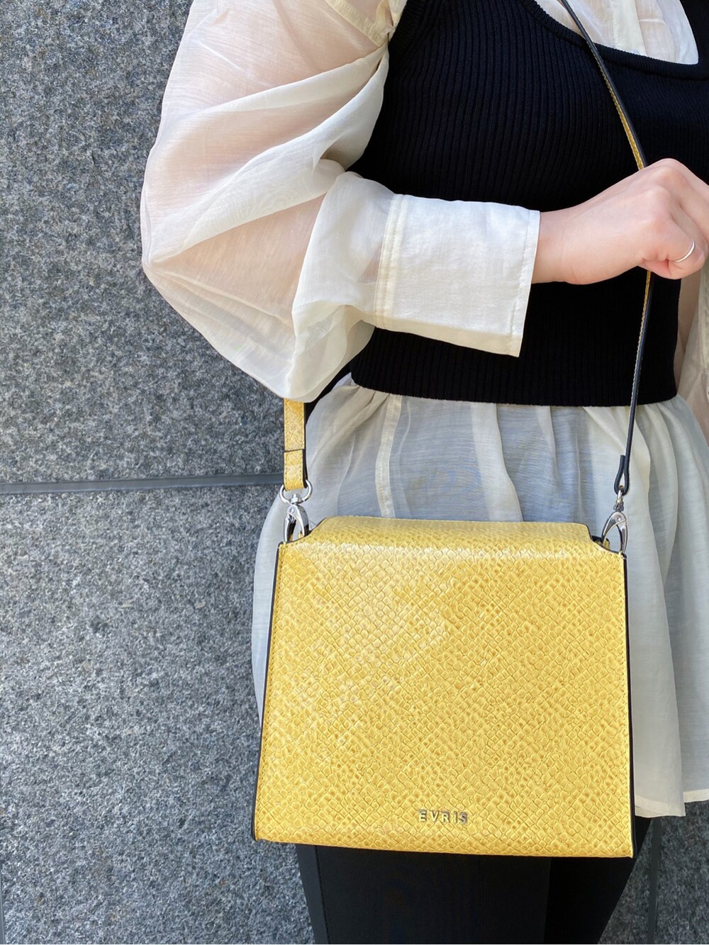 ブラック系のタンクトップ、ホワイト系のシャツ/ブラウス、ブラック系のサンダルを着用したレディースの春コーディネートの6枚目の写真