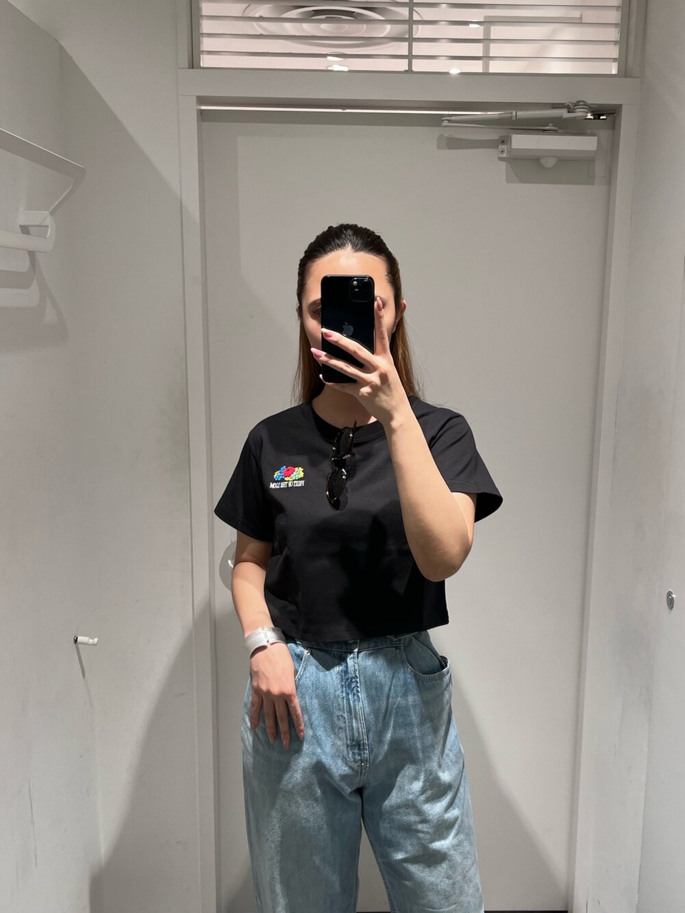 ブラック系のTシャツ/カットソー、ブルー系のデニムパンツ、ブラック系のショルダーバッグを着用したレディースの春コーディネートの3枚目の写真