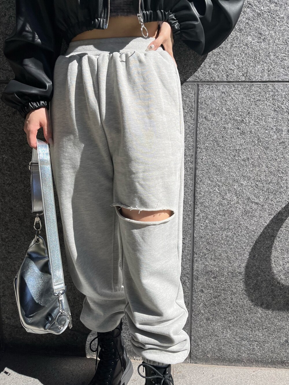 ブラック系のブルゾン、グレー系のスウェットパンツ、シルバー系のボディバッグ/ウエストポーチを着用したレディースの冬コーディネートの4枚目の写真