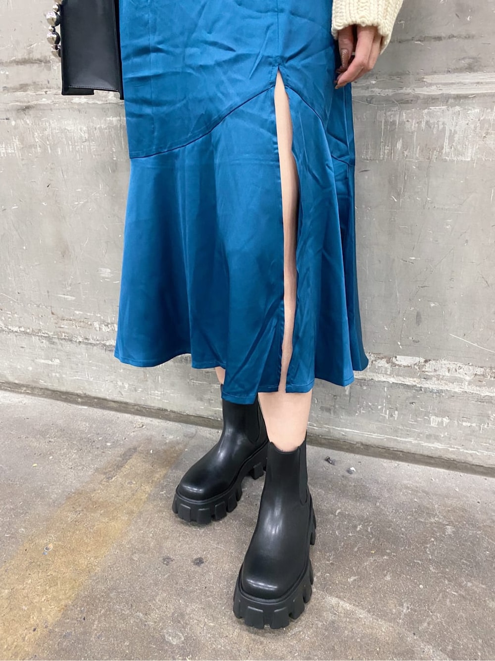 ホワイト系のニット/セーター、ブラック系のブーツ、ブルー系のスカートを着用したレディースの秋コーディネートの4枚目の写真