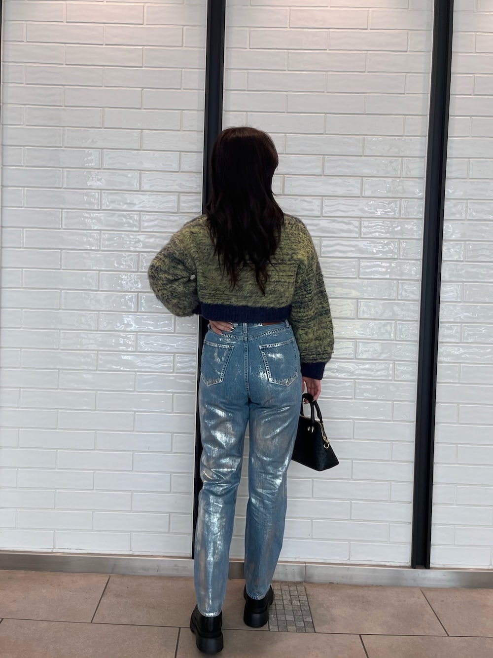 ブルー系のカーディガン/ボレロ、ブルー系のデニムパンツ、ブラック系のショルダーバッグを着用したレディースの秋コーディネートの2枚目の写真