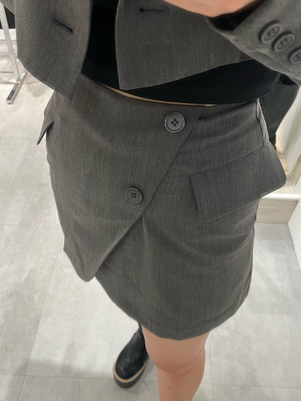 グレー系のテーラードジャケット、グレー系のスカート、ブラック系のTシャツ/カットソーを着用したレディースの春コーディネートの3枚目の写真