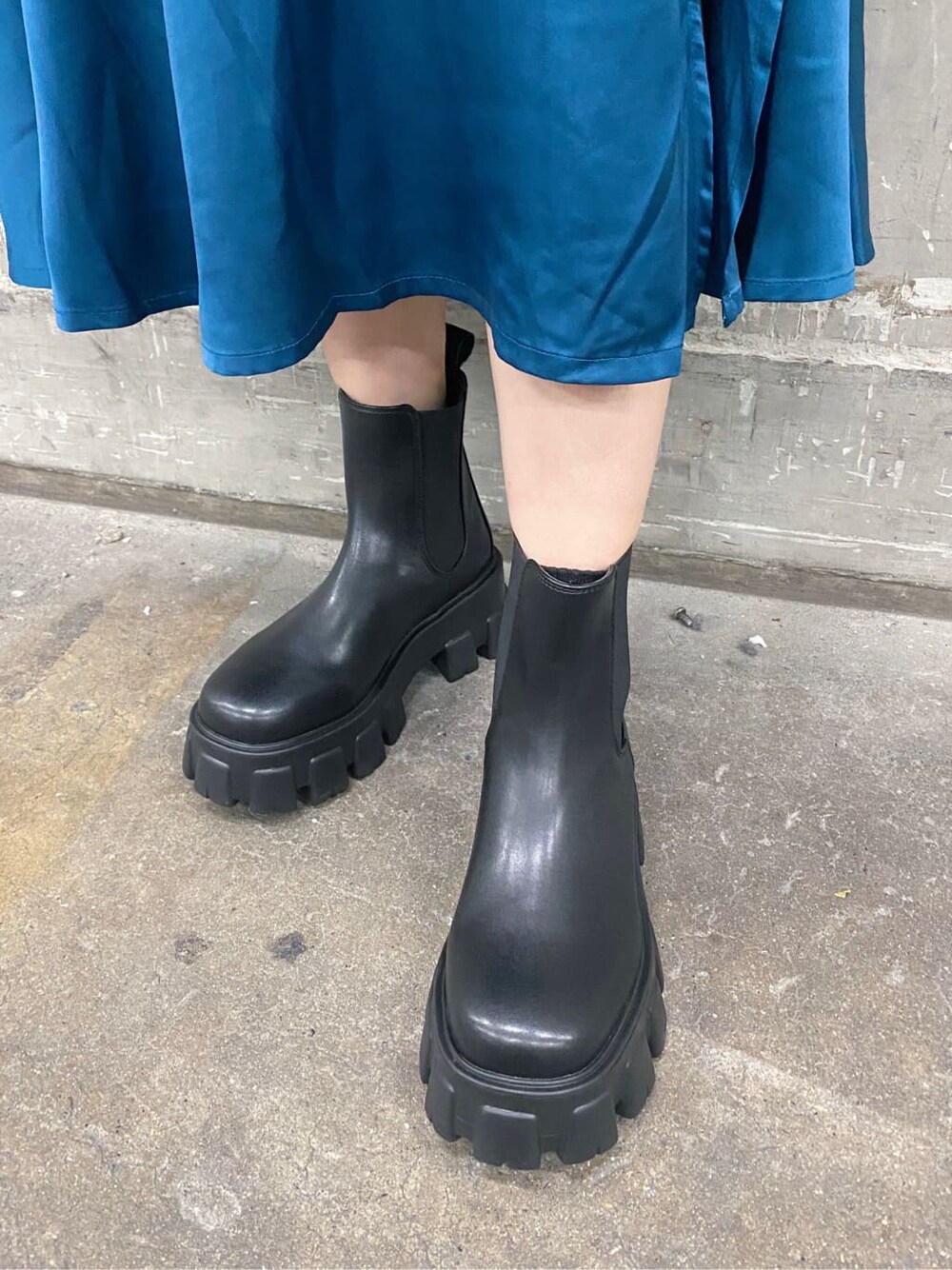 ホワイト系のニット/セーター、ブラック系のブーツ、ブルー系のスカートを着用したレディースの秋コーディネートの5枚目の写真