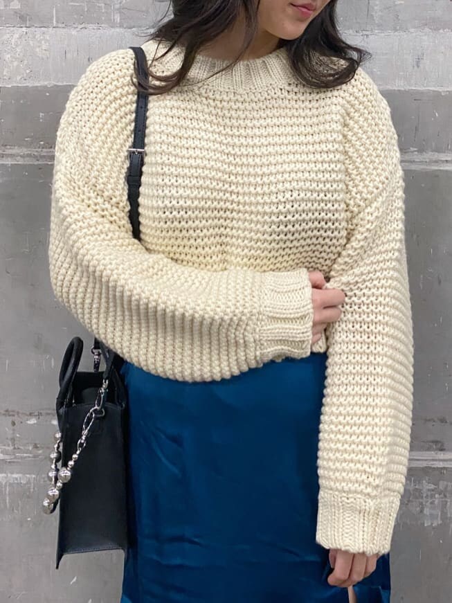 ホワイト系のニット/セーター、ブラック系のブーツ、ブルー系のスカートを着用したレディースの秋コーディネートの3枚目の写真