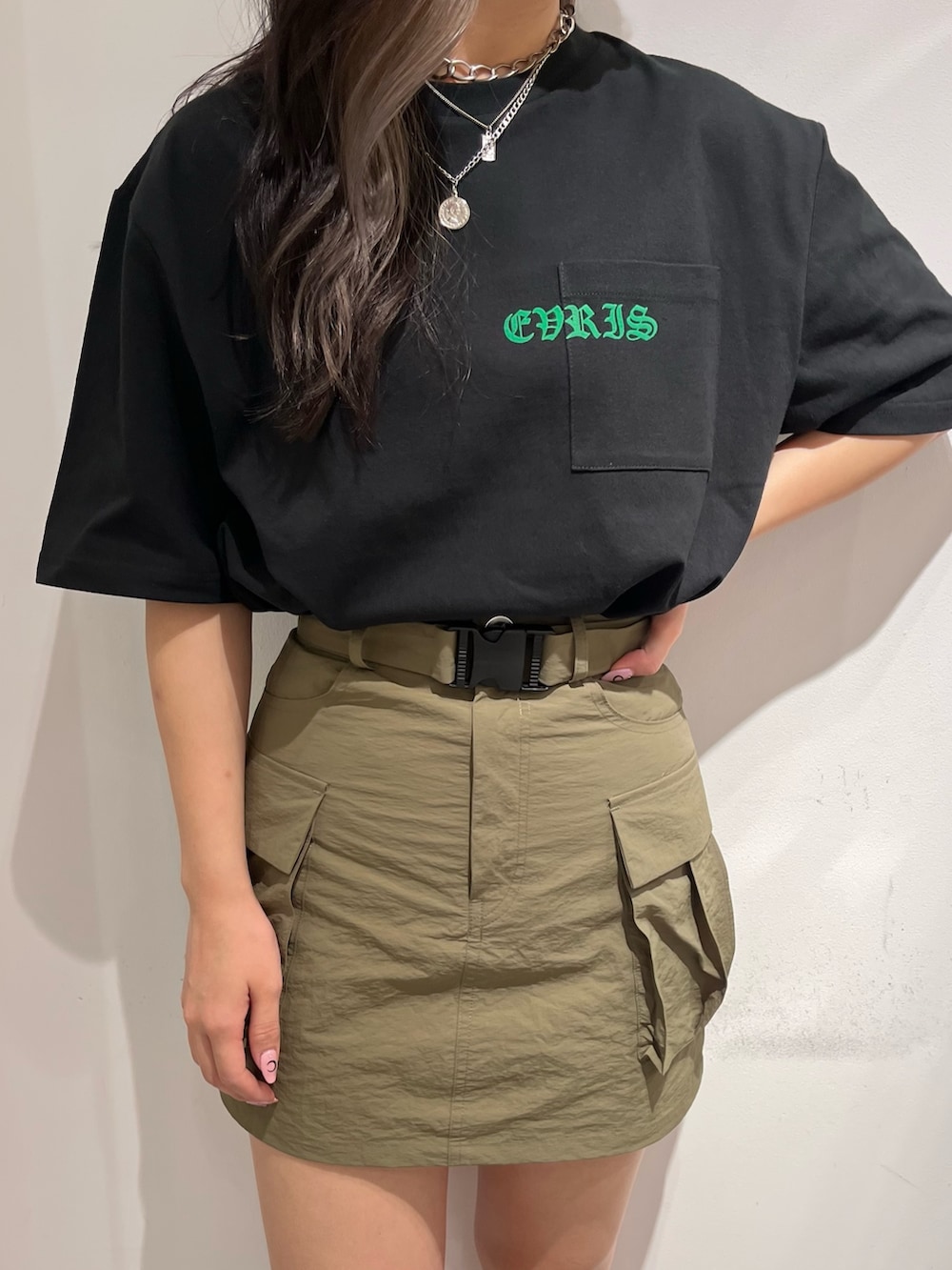 ブラック系のTシャツ/カットソー、グリーン系のスカート、ブラック系のブーツを着用したレディースの夏コーディネートの3枚目の写真