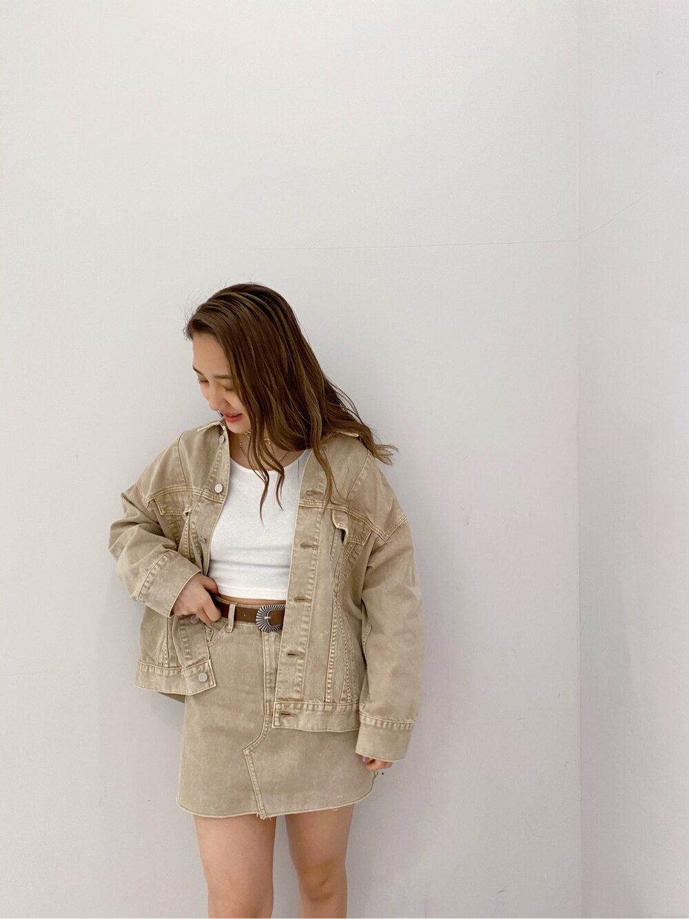 ベージュ系のデニムスカート、ベージュ系のデニムジャケット、ホワイト系のTシャツ/カットソーを着用したレディースの春コーディネートの4枚目の写真