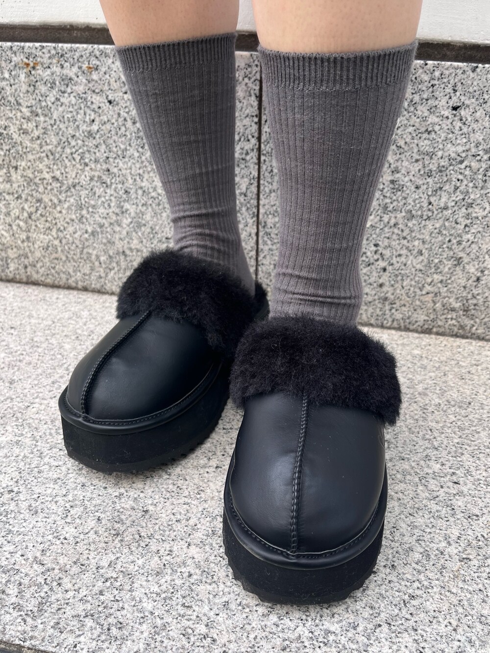 ブルー系のスウェット、グレー系のスカート、ブラック系のハンドバッグを着用したレディースの冬コーディネートの8枚目の写真