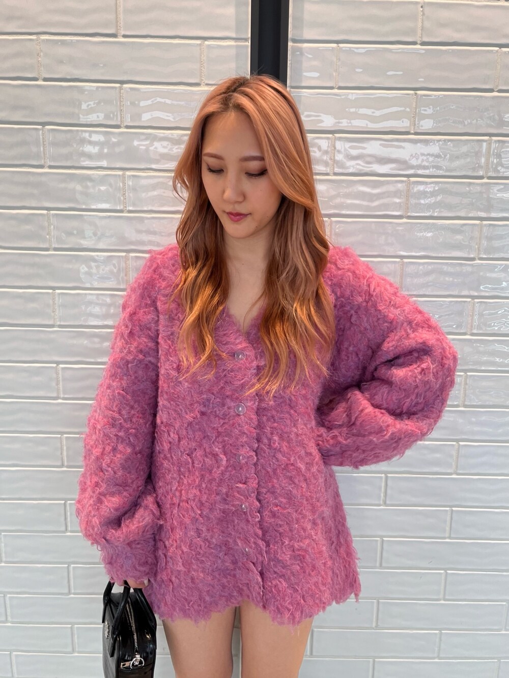 ピンク系のカーディガン/ボレロ、ブラック系のショルダーバッグ、ブラック系のブーツを着用したレディースの冬コーディネートの4枚目の写真