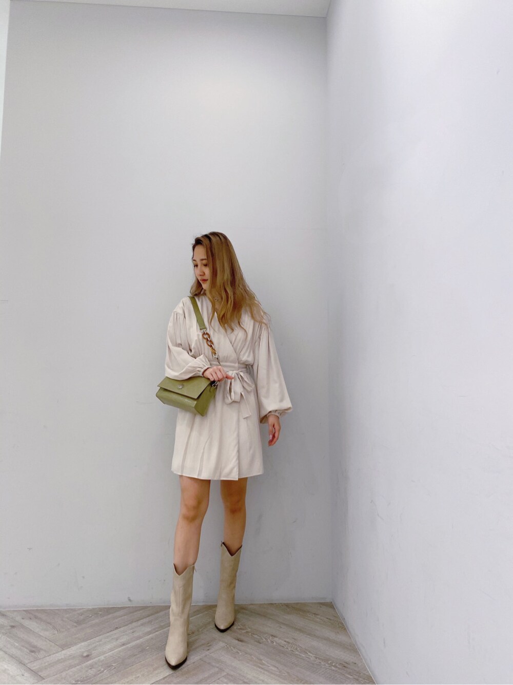 ベージュ系のブーツ、ホワイト系のワンピース、シルバー系のネックレスを着用したレディースの冬コーディネートの5枚目の写真