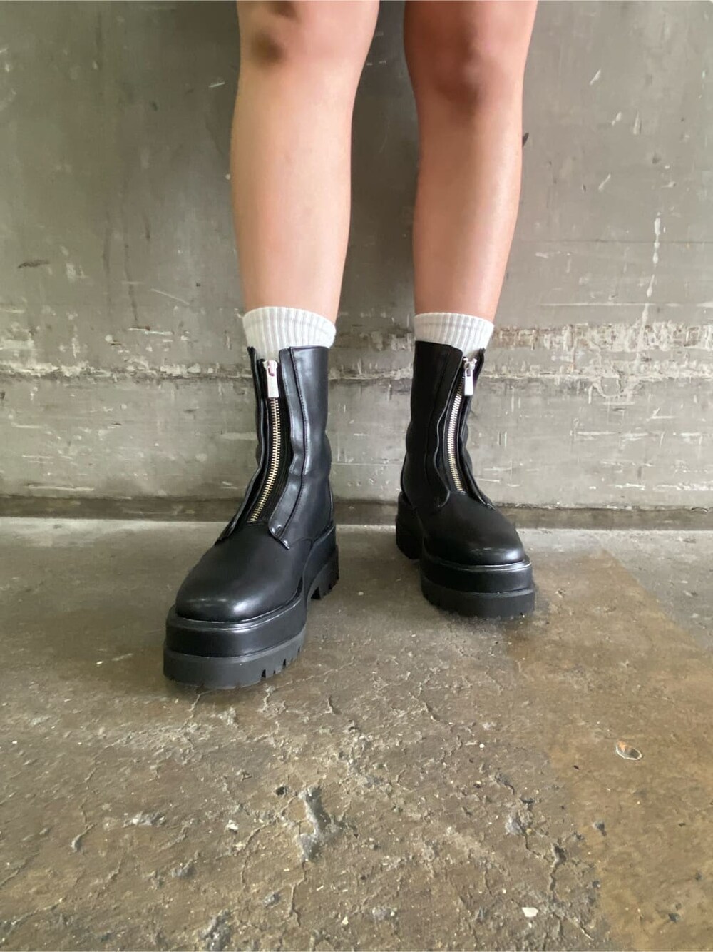 ホワイト系のショルダーバッグ、ブラック系のブーツ、パープル系のワンピースを着用したレディースの冬コーディネートの5枚目の写真