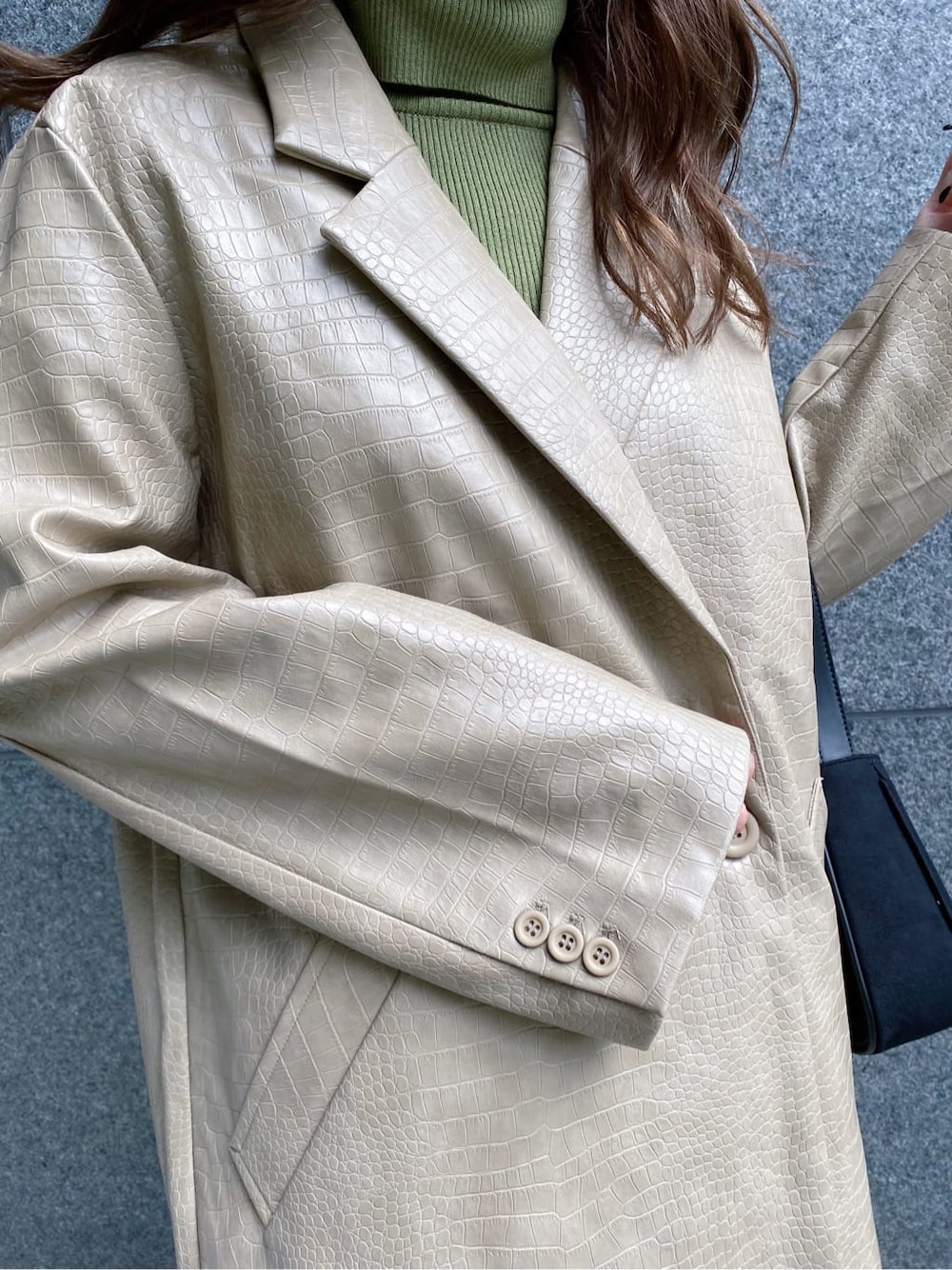 ブラック系のスカート、ブラック系のショルダーバッグ、ベージュ系のニット/セーターを着用したレディースの秋コーディネートの4枚目の写真