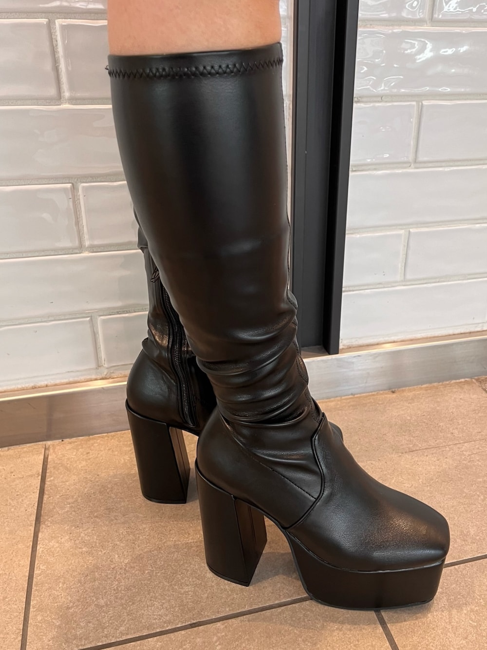 ピンク系のカーディガン/ボレロ、ブラック系のショルダーバッグ、ブラック系のブーツを着用したレディースの冬コーディネートの8枚目の写真