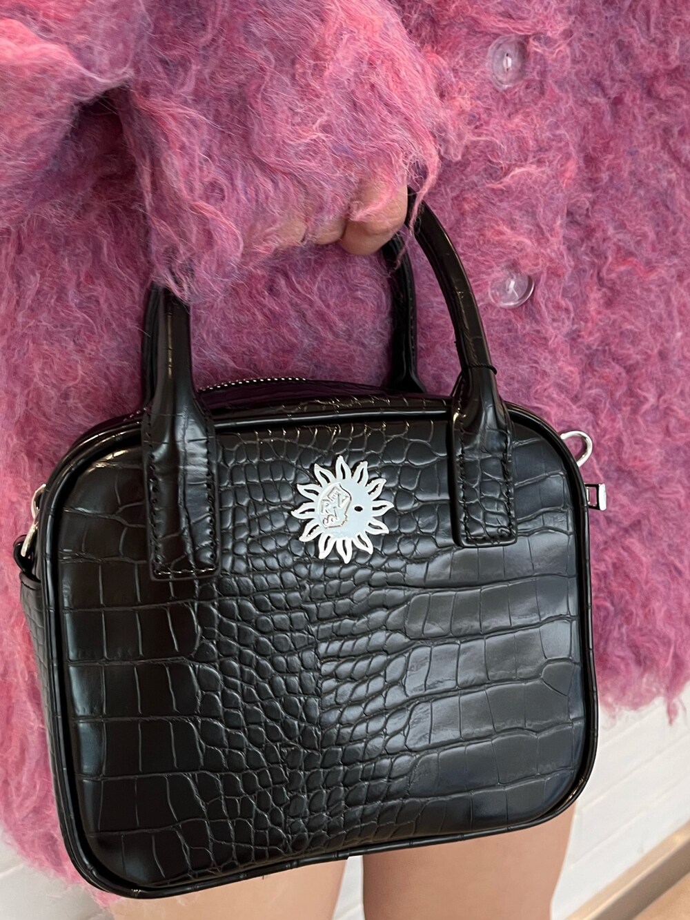 ピンク系のカーディガン/ボレロ、ブラック系のショルダーバッグ、ブラック系のブーツを着用したレディースの冬コーディネートの7枚目の写真