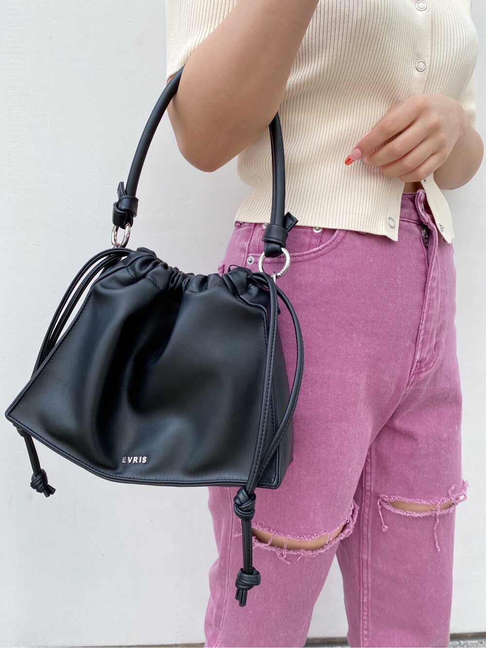 ブラック系のショルダーバッグ、ブラック系のサンダル、ホワイト系のTシャツ/カットソーを着用したレディースの春コーディネートの4枚目の写真