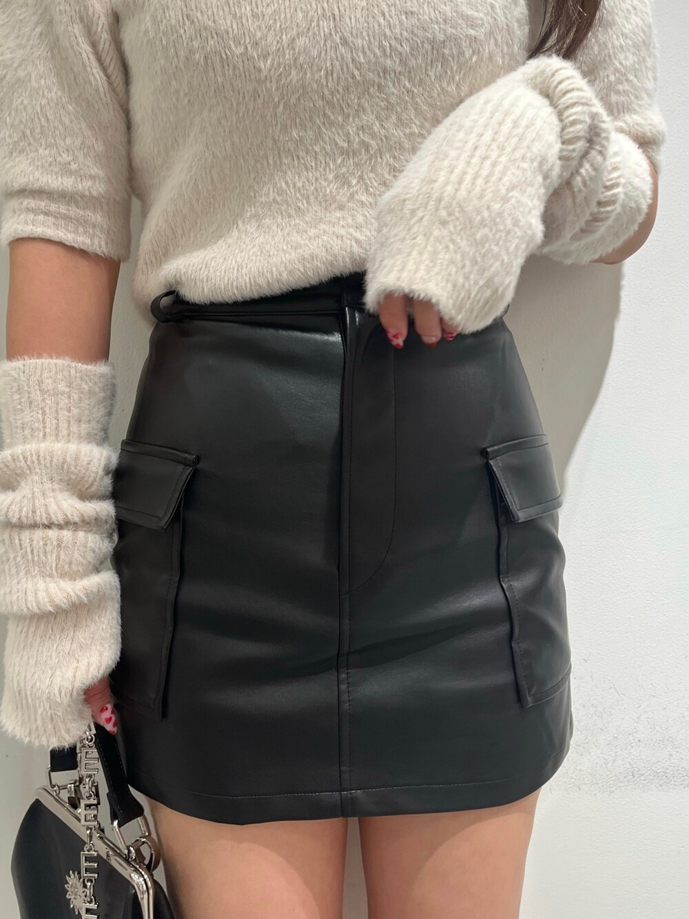 ホワイト系のニット/セーター、ブラック系のスカート、ブラック系のショルダーバッグを着用したレディースの冬コーディネートの3枚目の写真