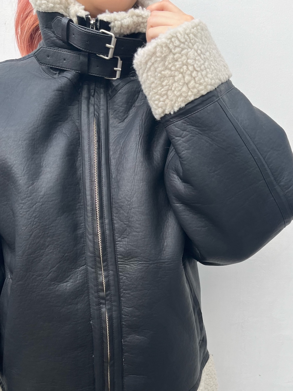 ブルー系のスウェット、グレー系のスカート、ブラック系のハンドバッグを着用したレディースの冬コーディネートの4枚目の写真