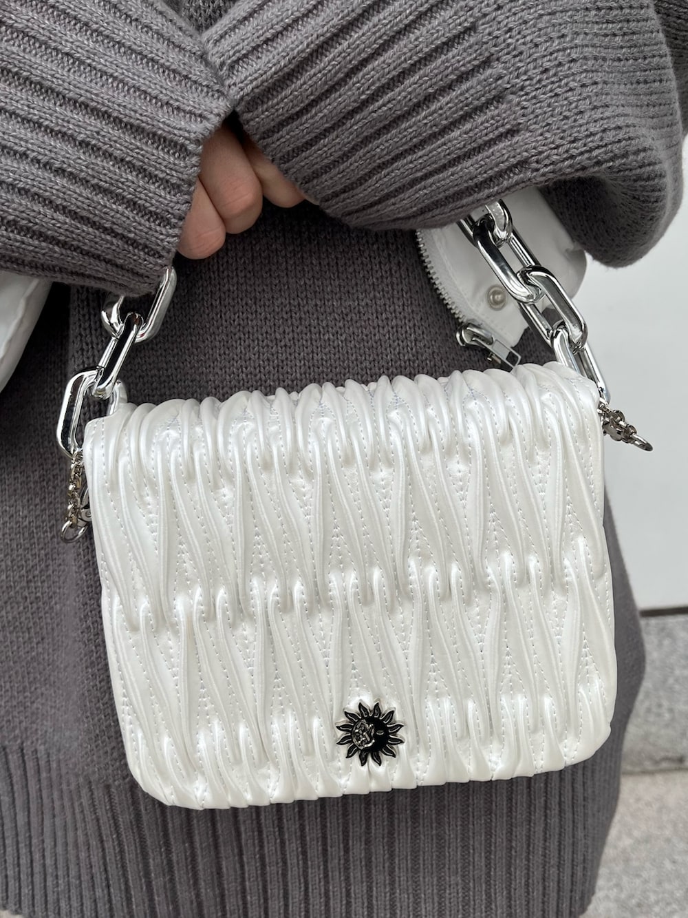 グレー系のニット/セーター、ホワイト系のショルダーバッグ、ホワイト系のブーツを着用したレディースの秋コーディネートの7枚目の写真