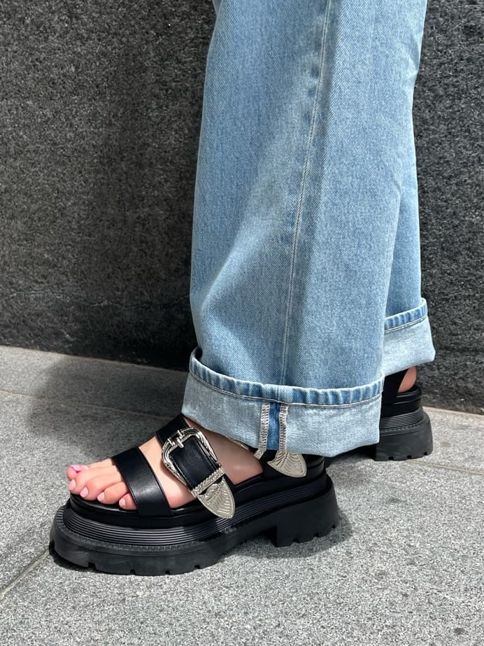 ブラック系のショルダーバッグ、ブルー系のデニムパンツ、ブラック系のニット/セーターを着用したレディースの夏コーディネートの8枚目の写真